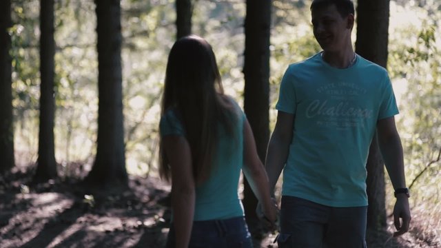 A Smiling couple walking along a forest