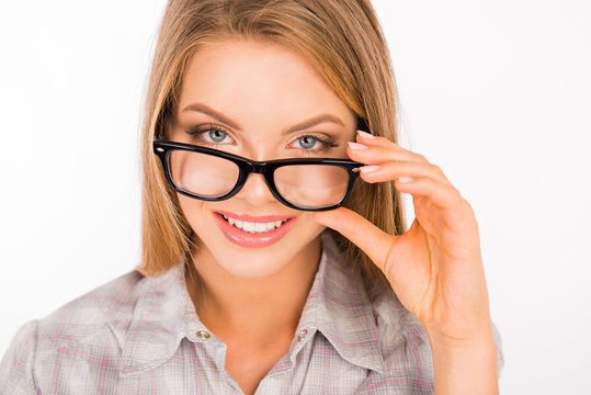 cute young woman adjusting her glasses and smiling