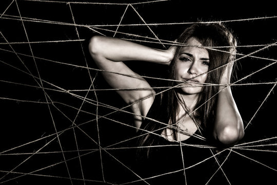 Young woman entangled the net of ropes