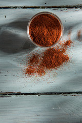 bowl of paprika on a wooden background