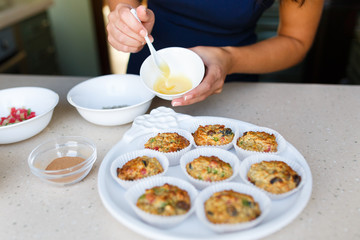 Hand of woman smears honey on cupcakes