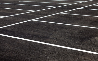White traffic markings on a gray asphalt parking lot © Alexandr Blinov