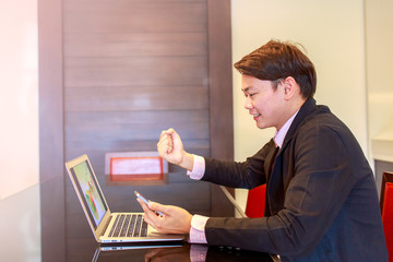 Happy smiling young man watching and working on computer laptop at home