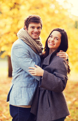 Fototapeta premium smiling couple hugging in autumn park