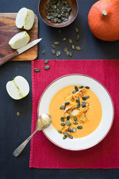 Pumpkin soup served with caramelized apples, pumpkin seeds and thyme