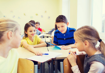 group of school kids writing test in classroom