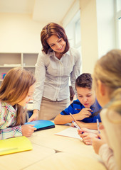 group of school kids writing test in classroom