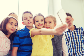 group of school kids taking selfie with smartphone