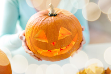 close up of woman with pumpkins at home