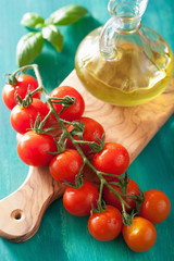 cherry tomatoes and olive oil over turquoise background