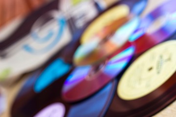 Multicolored art blurred background with vinyl records and CD