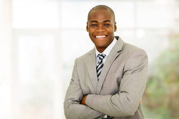 african businessman with arms folded in office