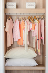 kid's wooden wardrobe with clothes hanging