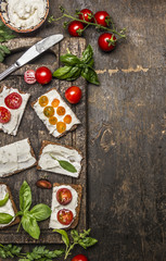 cream cheese sandwich with seasoning and tomatoes on rustic wooden background, top view, border, vertical. Healthy, diet or vegetarian food concept.