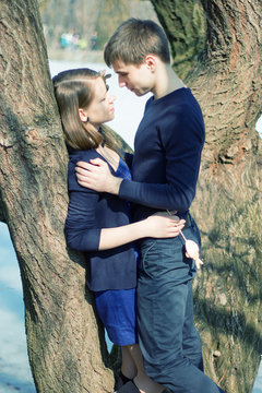 Romantic Teenage Couple By Tree InPark
