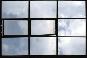 Dachfenster / Durch ein Glasdach scheint der blaue Wolkenhimmel