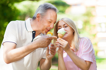     Happy couple eating an ice cream in a park