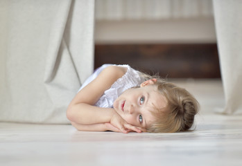 Obraz na płótnie Canvas Little girl lying on the floor on white background 