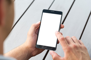 Man holding smart mobile phone on wooden table