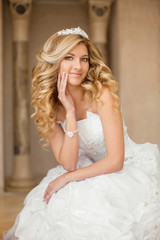 Fototapeta premium Beautiful smiling bride woman with long curly hair posing in wed
