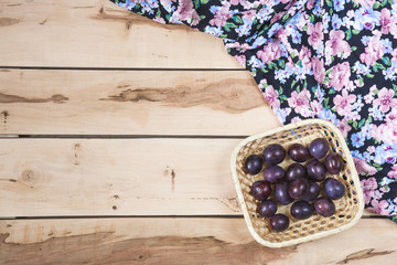 Ripe plums on the wooden background