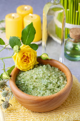 Bowl of green sea salt and yellow rose
