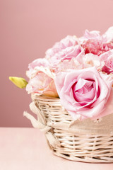 Fototapeta na wymiar Pink roses in white wicker basket