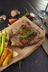 T-bone steak, a prepared piece of grilled T-bone steak brown sauce with mashed potato and vegetable on dining table decorated