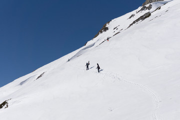 Snowboarders walking uphill for freeride