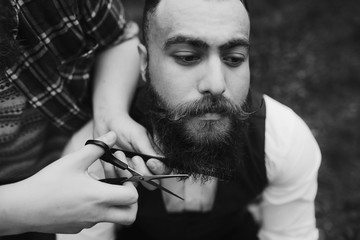 barber shaves a bearded man