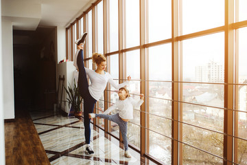 Mother learning daughter to make a high leg strech