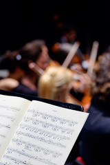 Naklejka premium spartito con note musicali in orchestra durante un concerto