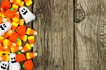 Halloween candy side border against a rustic wood background