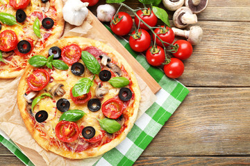 Tasty pizza with vegetables and basil on table close up