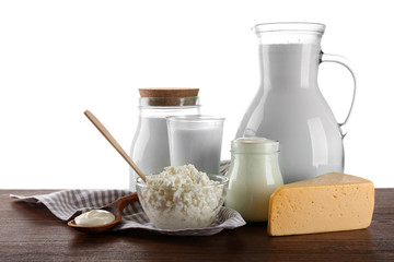 Dairy products on wooden table on white background
