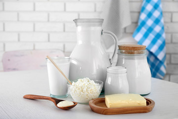 Dairy products on wooden table, on brick wall background