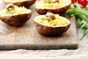 Baked potatoes with cheese and mushrooms on table close up