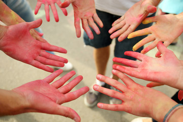 Hands of young people with Indian dyes on Holi color festival
