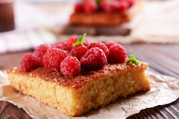 Fresh pie with raspberry on parchment on wooden table, closeup