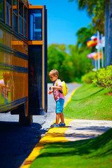 young boy, kid getting on the school bus, ready to go to school