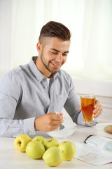 Fototapeta premium Young man having light breakfast