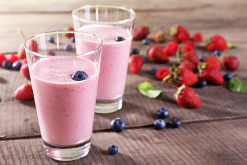 Glasses of berry smoothie on wooden table, closeup