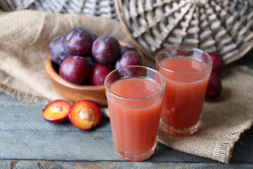 Delicious plum juice with fruits on wooden table close up