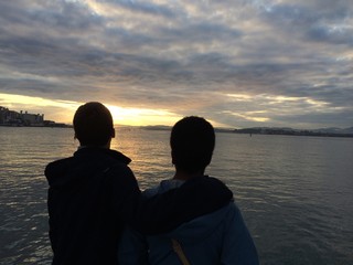 pareja contemplando el amanecer frente al mar