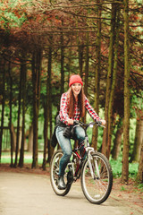 girl relaxing in autumnal park with bicycle.