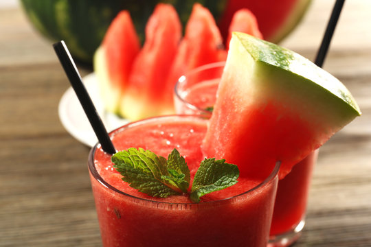 Glasses of watermelon juice on wooden table, closeup