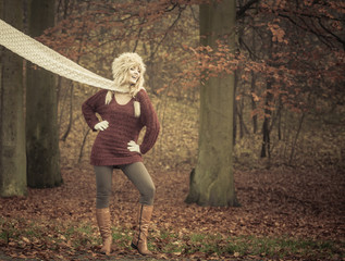 Fashion woman in windy fall autumn park forest.