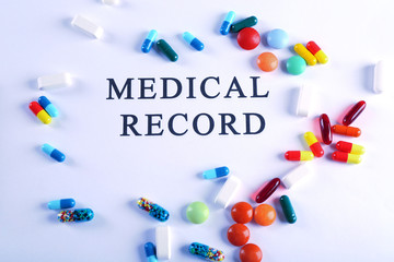 Inscription MEDICAL RECORD and pills isolated on white