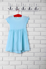 Child dress on hanger on white wall background