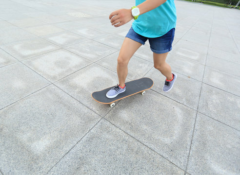 young woman skateboarder riding skateboard on city